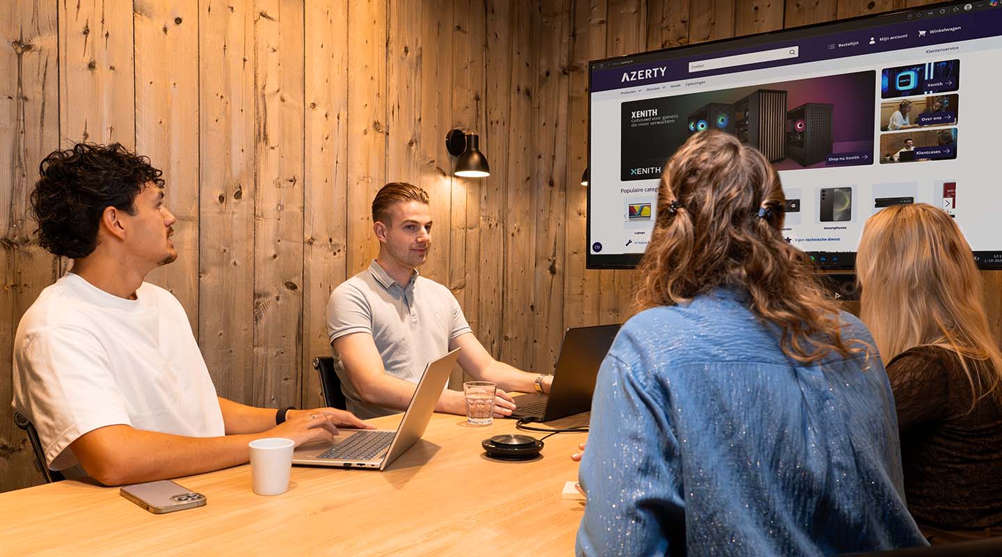 Azerty-collega&rsquo;s overleggen aan tafel met de Azerty-webshop op het scherm