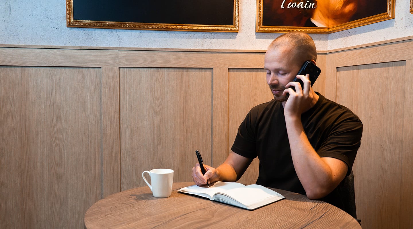 Recruiter van Azerty maakt telefonisch notities in een notitieboek