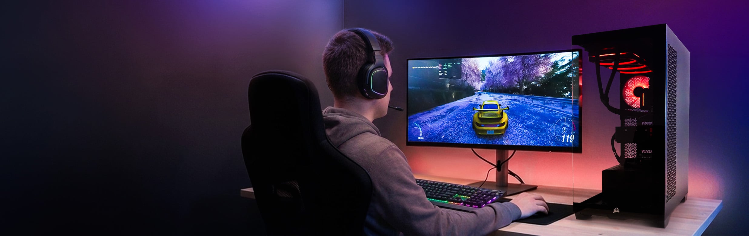 Gamer met headset speelt een racegame op een Xenith gaming-pc met RGB-verlichting