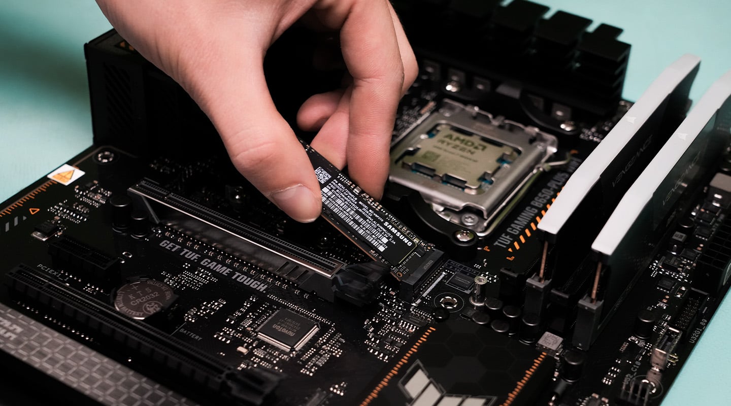 Hand plaatst een M.2 SSD op een moederbord met AMD Ryzen-processor